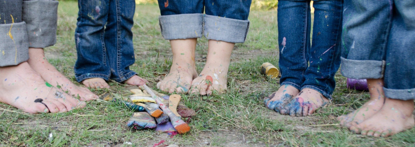 5 barfüßige Menschen im Gras